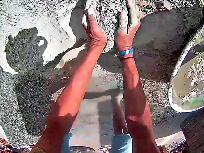 Standing over uneven stone ground at an outdoor work site.