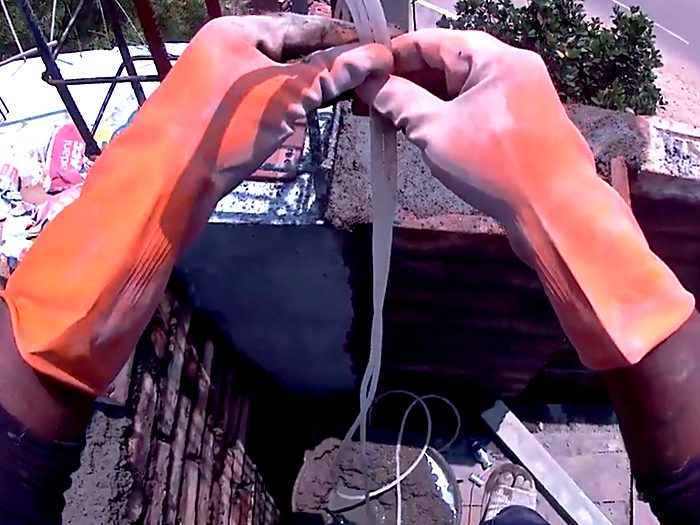 Gloved hands working a rope tie at height.