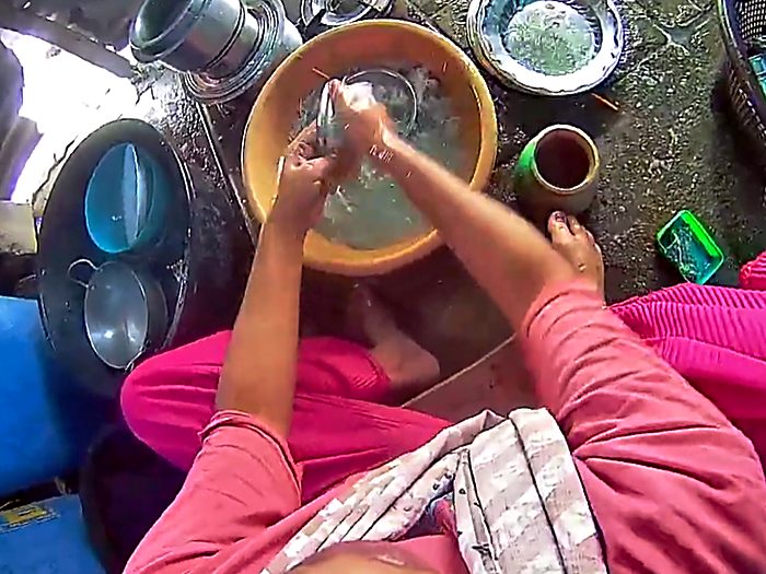 Washing steel vessels in a basin of water.