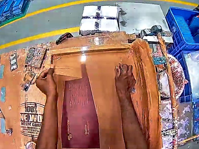 Hands positioning a component on a workbench.